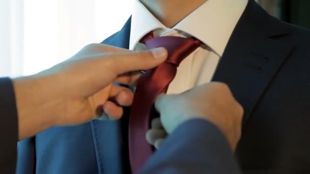 Groomsmen auttaa sulhanen laittaa solmio
 - Materiaali, video