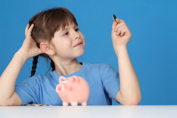The little girl looks at a penny - Φωτογραφία, εικόνα