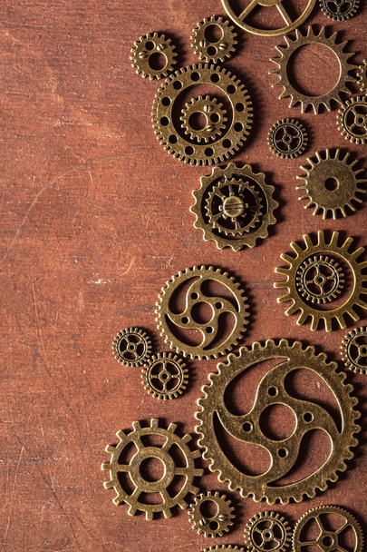 steampunk mechanical cogs gears wheels on wooden background - Photo, Image