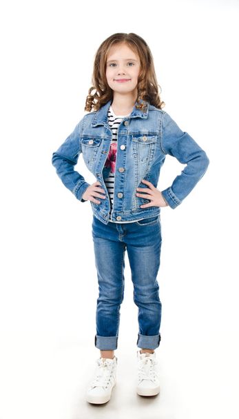 Portrait of adorable happy little girl in jeans  - Фото, изображение