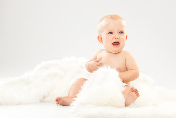 beautiful blonde hair blue eyes baby in a white room - Фото, изображение
