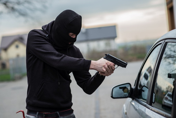 Şoföre bir silahı işaret araba hırsızı - Fotoğraf, Görsel