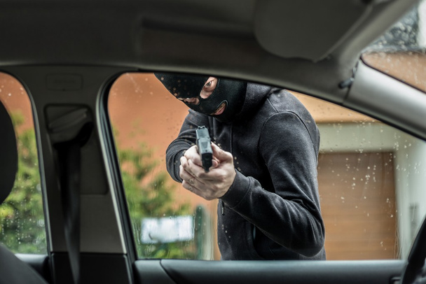 autó tolvaj rámutat a pisztolyt, a vezető - Fotó, kép