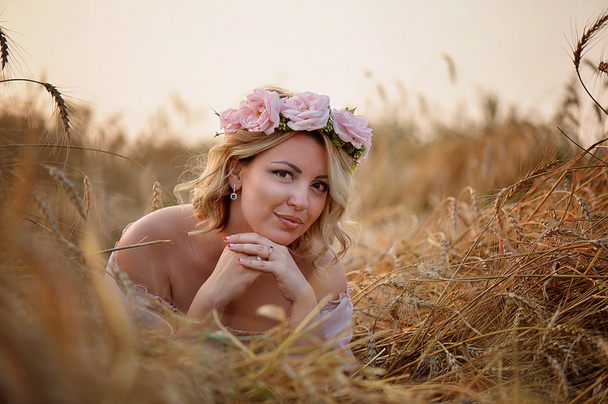Beautiful girl with pink flowers wreath. Lovely hair and makeup . - Фото, изображение