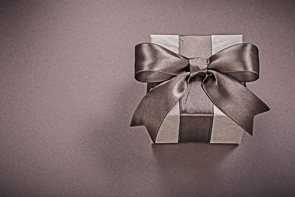 Gift box with bow on brown background holidays concept - Foto, Bild