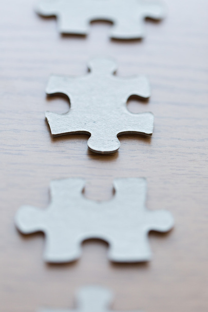 Close up van puzzelstukjes op houten oppervlak - Foto, afbeelding