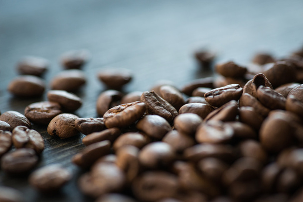 Roasted coffee beans on old wooden table - Foto, imagen