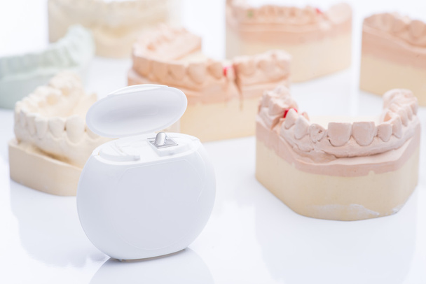 Зубні форми з зубною ниткою на яскраво-білому столі
 - Фото, зображення