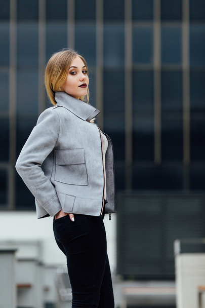 Young woman standing in front of office buildings - Foto, Bild