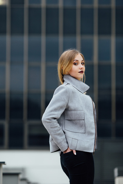 Young woman standing in front of office buildings - Valokuva, kuva