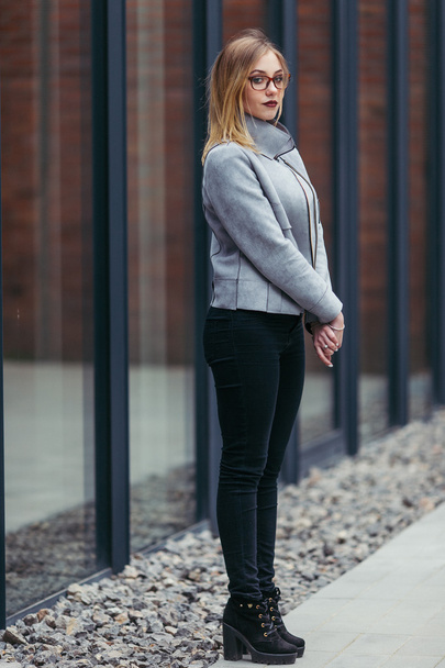 Young woman standing in front of office buildings - Foto, Imagen