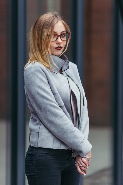 Young woman standing in front of office buildings - Fotoğraf, Görsel