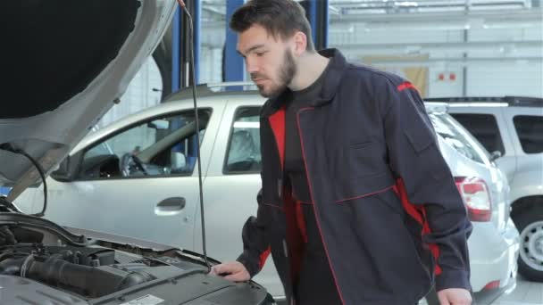Μηχανικός φαίνεται κάτω από το καπό του αυτοκινήτου στην υπηρεσία αυτοκινήτων - Πλάνα, βίντεο