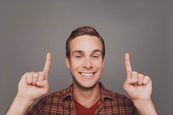 Handsome man with beaming smile gesturing with fingers under hea - Photo, Image