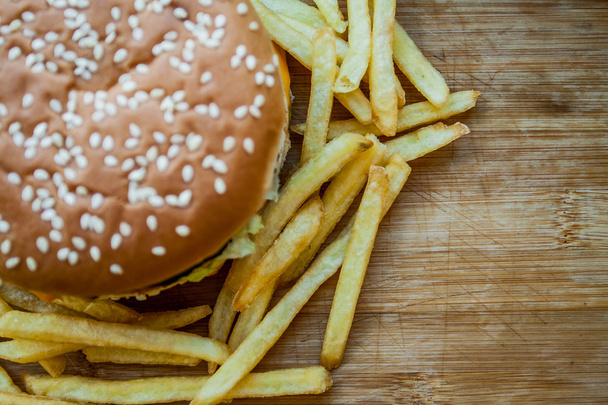 Fast food set big hamburger and french fries on wood background - Photo, Image