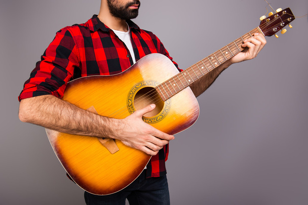 Close up portrait of young bearded man holding guitar - Foto, imagen