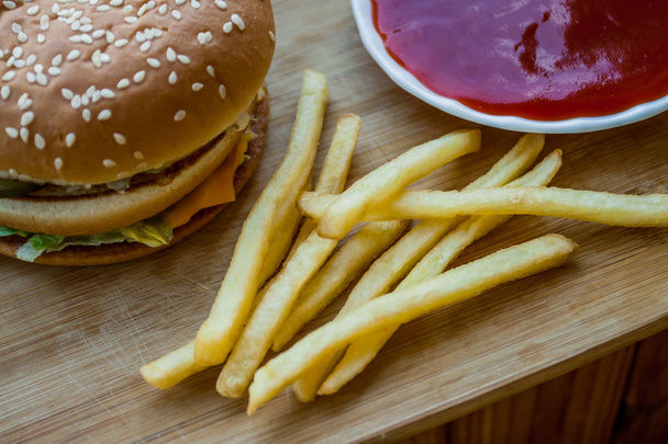 Fast food set big hamburger and french fries on wood background - Photo, Image