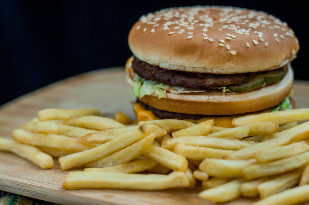 Fast food set big hamburger and french fries on wood background - Фото, изображение