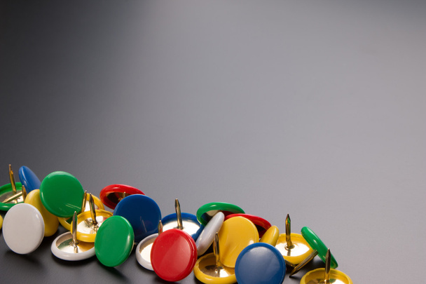Group of colorful push pins on black board background. - Photo, Image