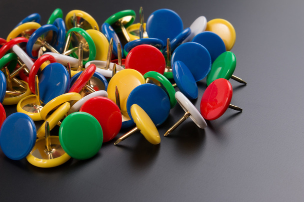 Group of colorful push pins on black board background. - Photo, Image