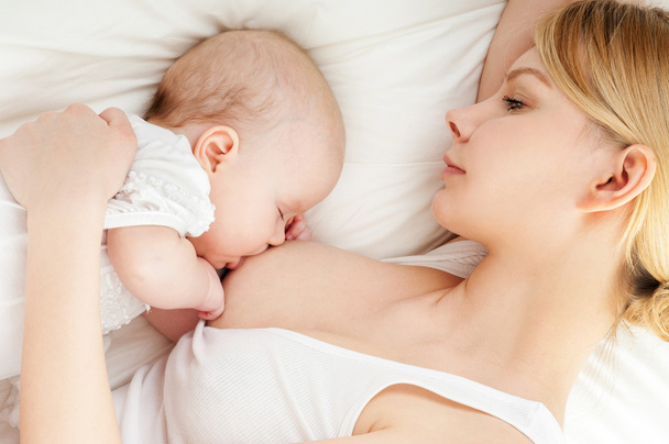 Young mother breastfeeds her baby - Fotografie, Obrázek