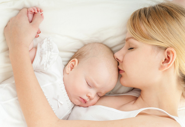 Young mother and her baby sleeping in bed - Foto, Imagen