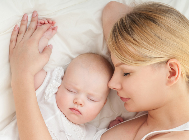 Young mother and her baby sleeping in bed - Foto, Bild