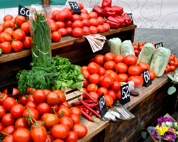 Grandes tomates ecológicos naturales rojos y perejil en el mercado agrícola
 - Foto, Imagen