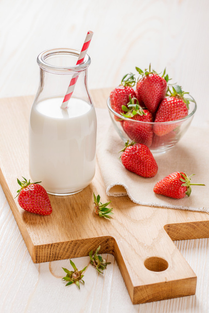 Milk and strawberry on white wooden background - Photo, image
