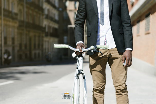 Handsome african man on bike in the city. - Photo, image