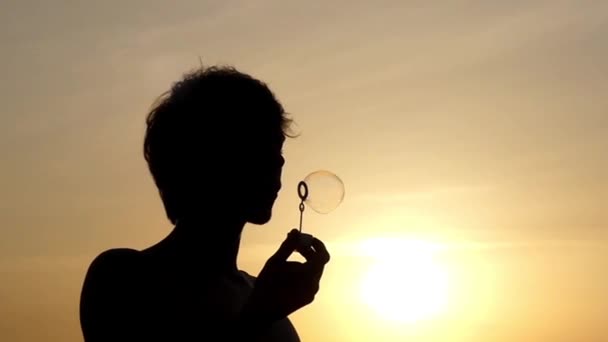 die Silhouette des Menschen blasen Blasen bei Sonnenuntergang. Schöne Action in Zeitlupe. - Filmmaterial, Video