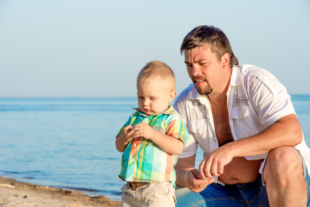 Apja és a fiatal fiú a strandon. - Fotó, kép