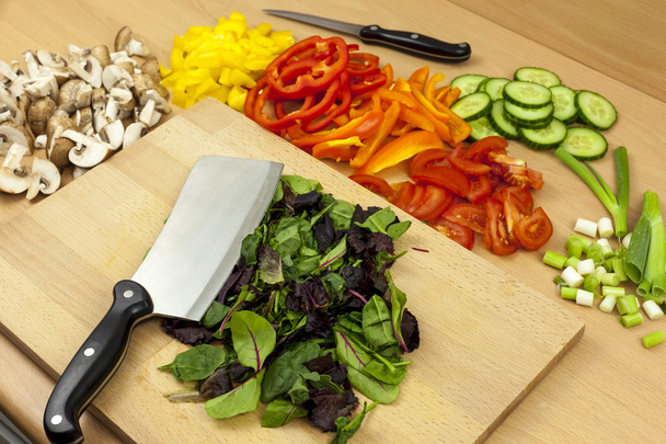 Fejsze kés szóló tetején néhány frissen vágott babyleaf saláta - Fotó, kép