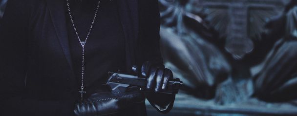 close-up hands of girls in black leather gloves, grip gun - Foto, Bild