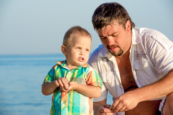 Père et jeune fils sur la plage
. - Photo, image