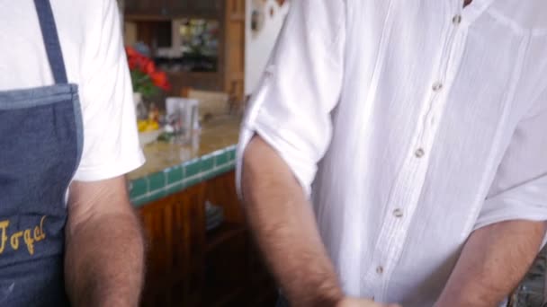 Slow motion of an active senior and middle aged man working in a kitchen - Video, Çekim