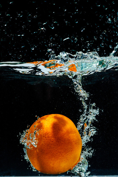 水の中をジャブジャブとオレンジ色の高速度撮影  - 写真・画像