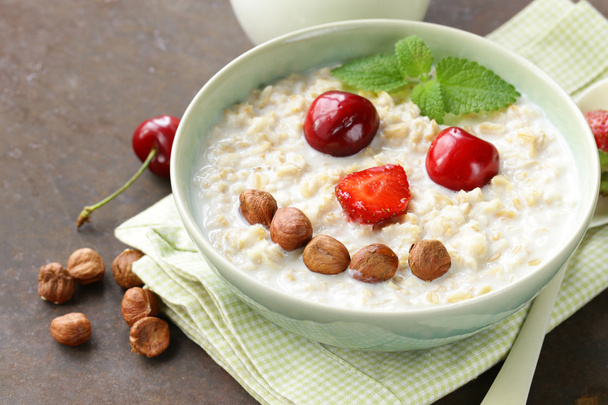 овсяная каша с молоком и ягодами - здоровый, забавный завтрак
   - Фото, изображение