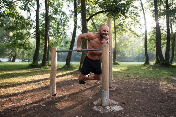 Young Sportsman Working Out In A Park - Фото, зображення