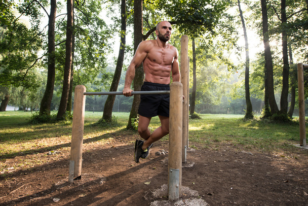 Young Sportsman Working Out In A Park - Foto, immagini