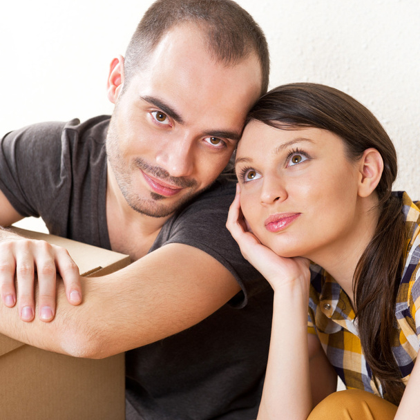 若いカップル ボックスを床に座って新しいアパートで、 - 写真・画像