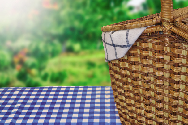 Корзина для пикника на столе с голубой клетчатой скатертью
 - Фото, изображение