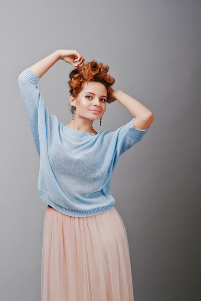 Studio portrait of young red haired curly girl at blue blouse an - Foto, afbeelding