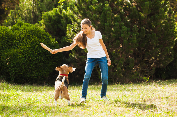 Girl plays with a dog in the yard - Foto, Bild