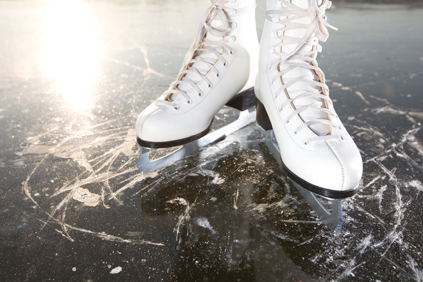 breed schaatsen op ijs met zon weerspiegeld in achter - Foto, afbeelding
