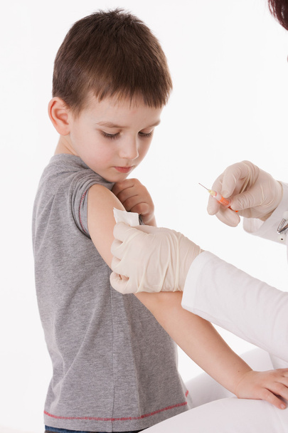 Doctor giving a child injection in arm on isolated image. - Photo, Image