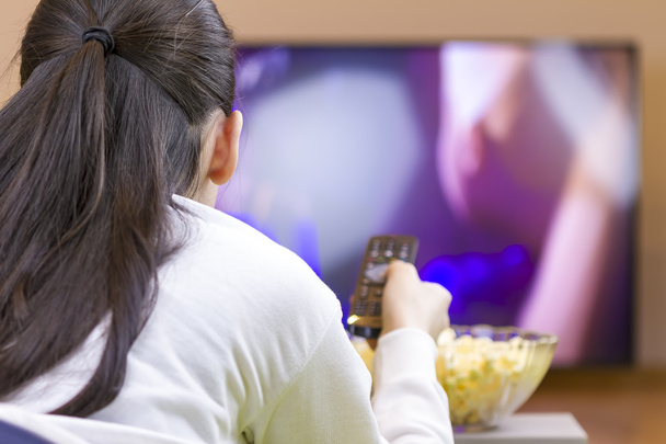 Adolescente avec télécommande regarder la télévision intelligente
 - Photo, image