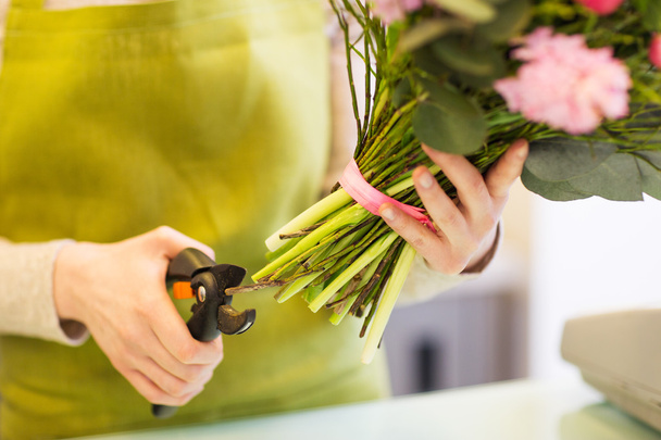 close up of florist woman with flowers and pruner - Фото, зображення