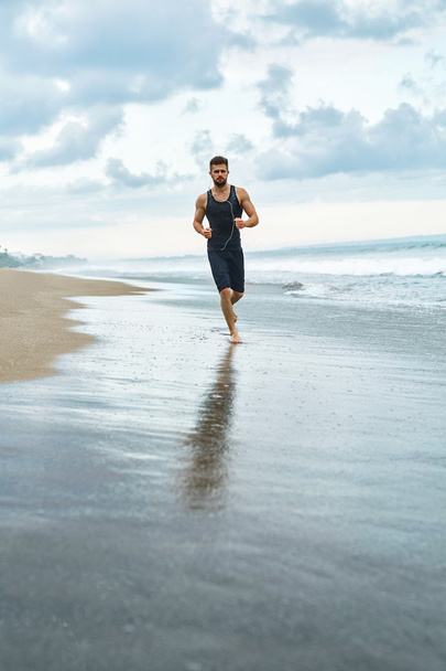 Fitness Man Running On Beach. Runner Jogging During Outdoor Workout - Фото, изображение