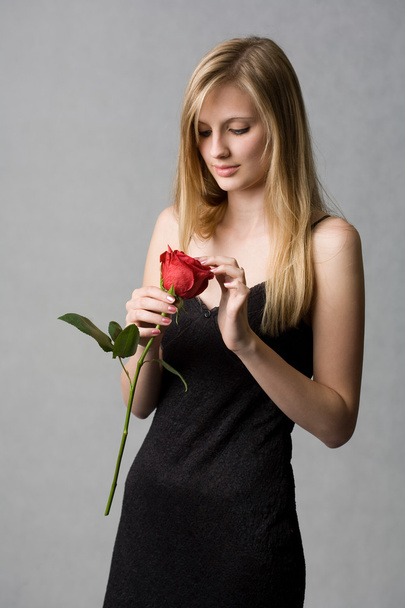 Gorgeous young blond woman holding rose. - Fotó, kép